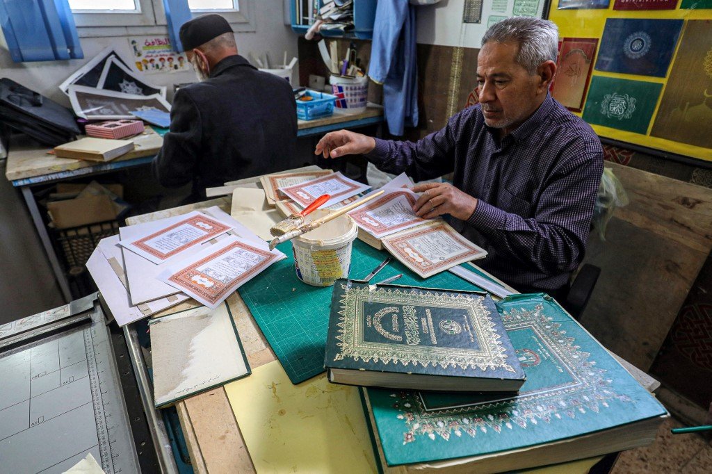 Artisan baik pulih al-Quran Libya, Khaled al-Drebi sedang membaik pulih Quran lama di bengkelnya di Tripoli. - AFP