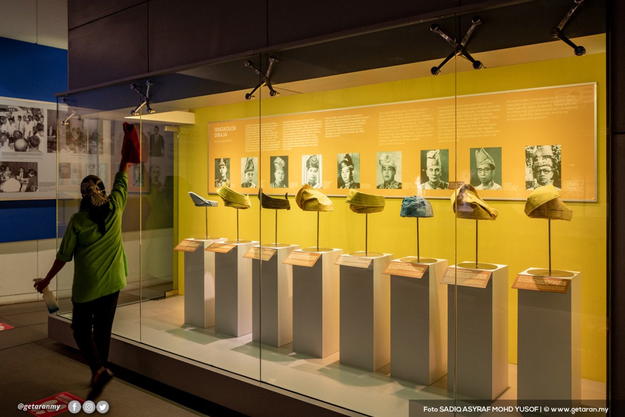 Seorang pekerja pembersihan menjalankan proses sanitasi di dalam bilik pameran di Muzium Negara.