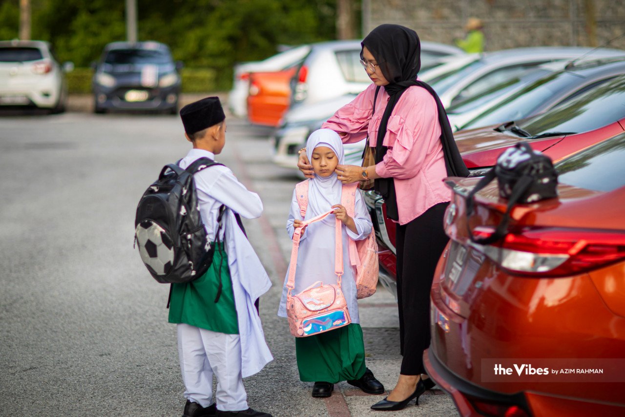 Seorang ibu menghantar dua anaknya ke Sekolah Rendah Islam Al-Hafiz di Cyberjaya. - Gambar oleh Azim Rahman