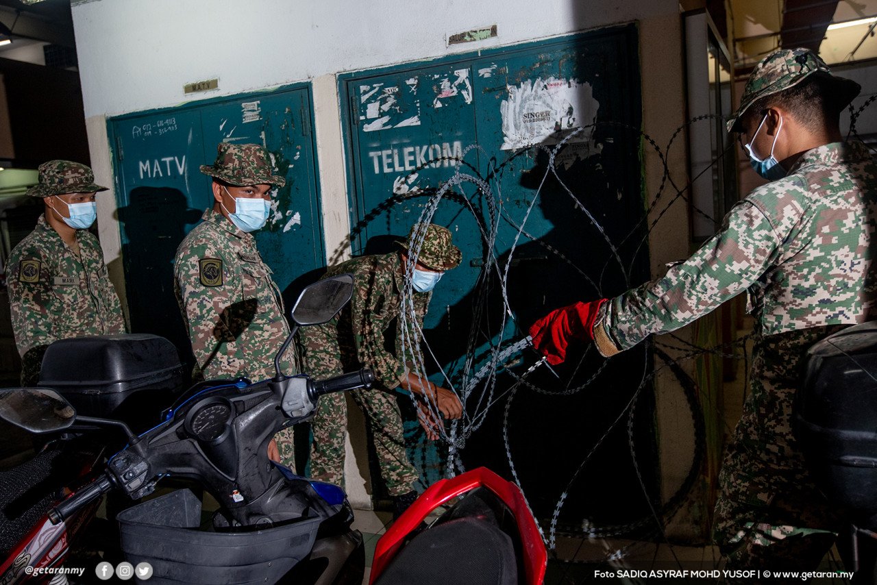 Beberapa anggota tentera memasang kawad duri di kawasan PPR Kampung Baru Air Panas, Kuala Lumpur, tengah malam tadi.