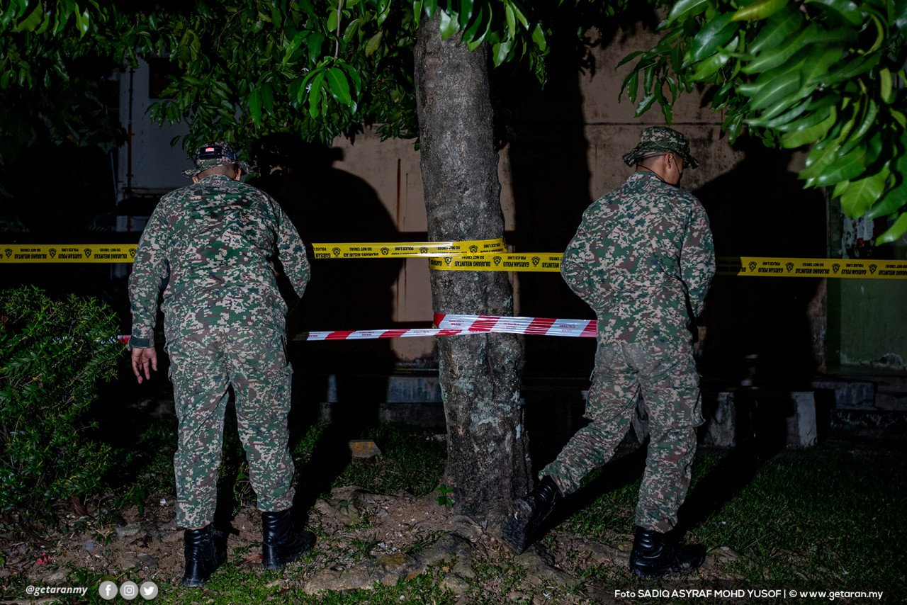 Dua anggota tentera memeriksa penghadang yang dipasang di kawasan flat di Bandar Baru Sentul, tengah malam tadi susulan pelaksanaan PKPD.