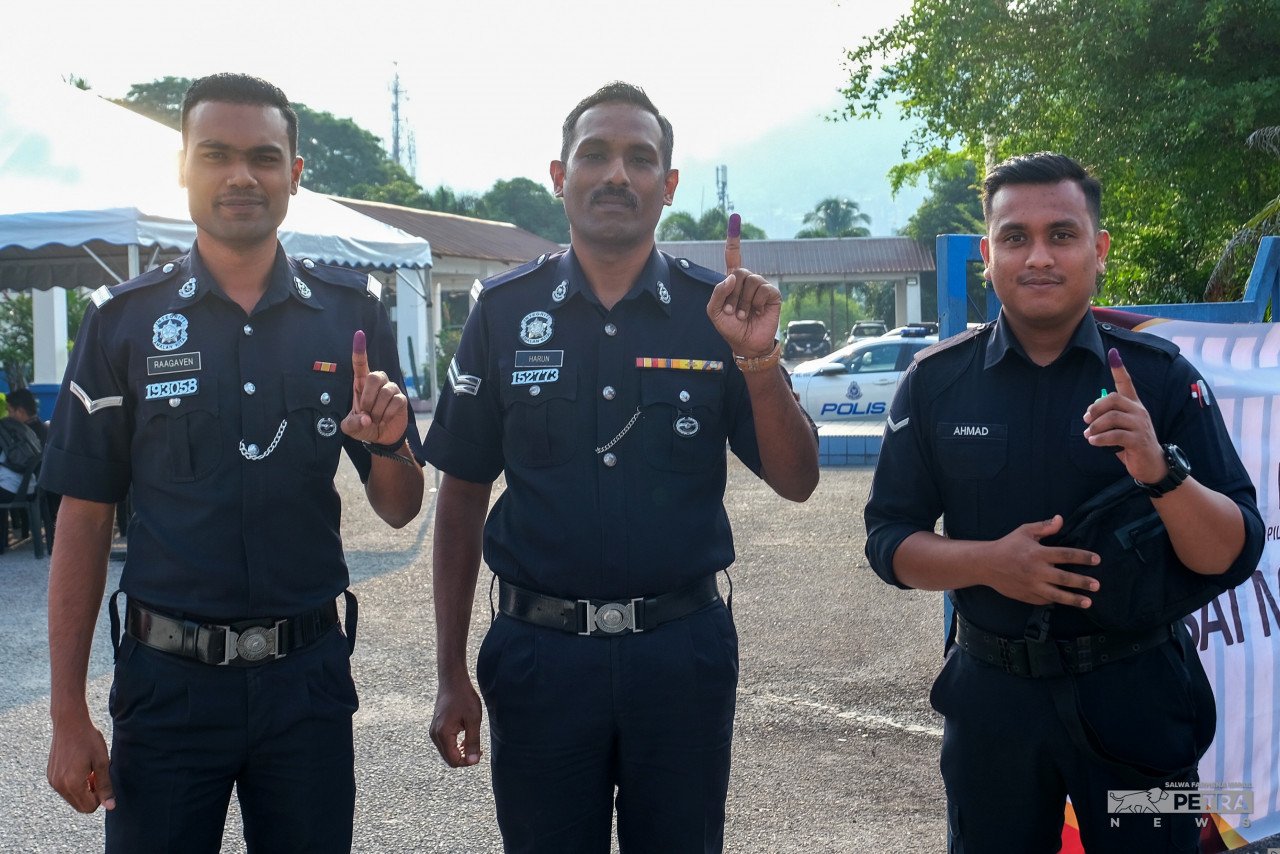 Anggota polis menunjukkan jari mereka selepas mengundi awal di Balai Polis Hulu Klang. gambar Salwa Farhana Ismail 