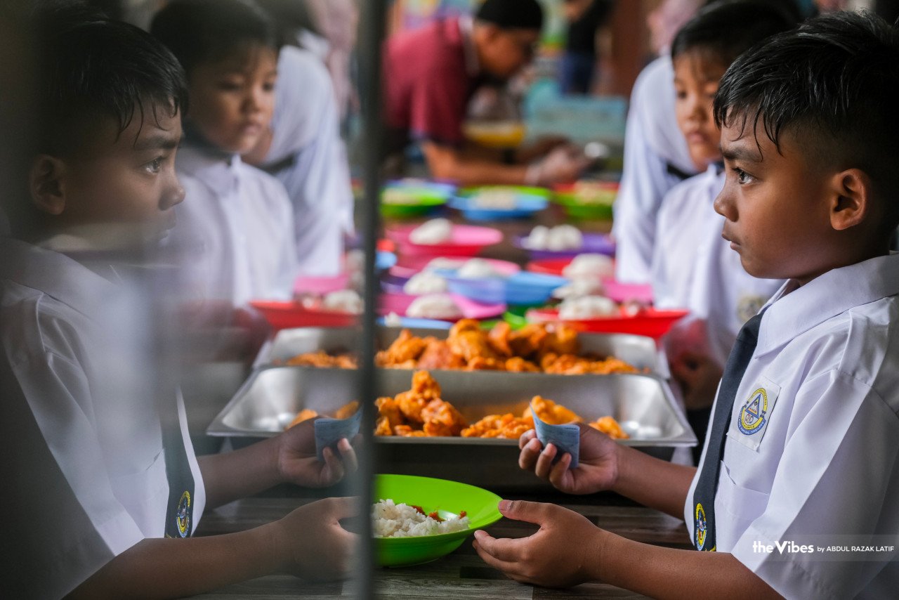 Murid-murid ini beratur bagi membeli makanan di kantin sekolah.