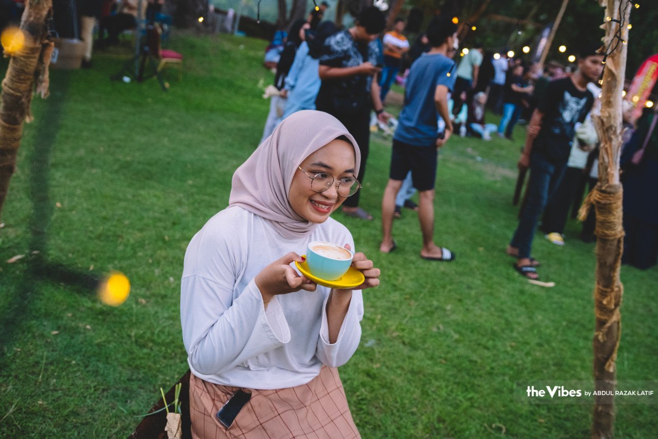 Seorang wanita bergambar dengan minuman kopi pada Festival Kopi Kemaman di Resort World Kijal, Kemaman, Terengganu