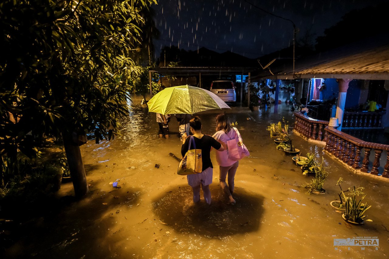 Penduduk meredah banjir di Kampung Baru Alma dan Taman Permai Jaya di Bukit Mertajam, baru-baru ini.