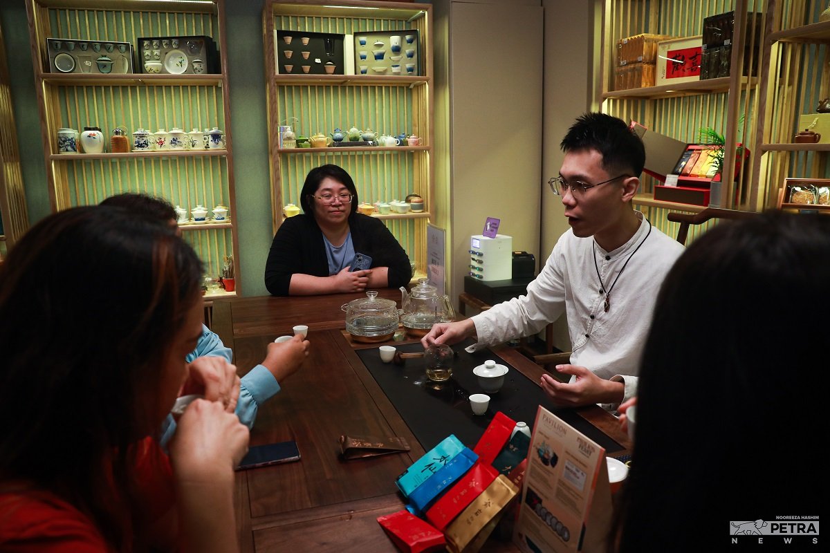 Pelanggan diberi penerangan mengenai teh yang dijual. gambar Nooreeza Hashim