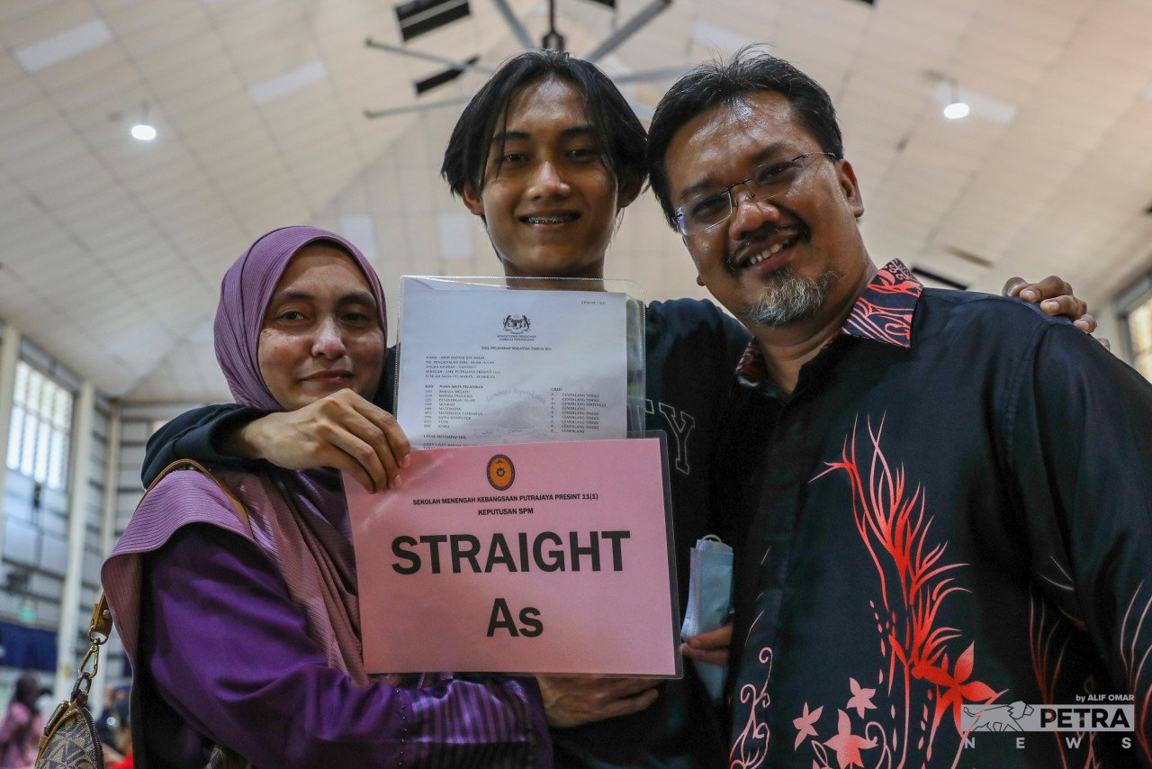 Kejayaan pelajar ini memperoleh keputusan cemerlang dalam SPM 2021 turut dikongsi ibu dan bapanya di SMK Putrajaya 11(1). - Gambar oleh Alif Omar