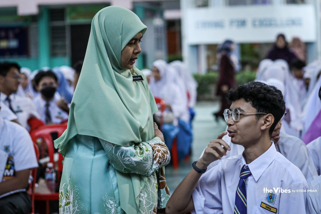 Seorang guru di SMK Jalan Empat, Bandar Baru Bangi berbual dengan salah seorang pelajar sebelum memasuki dewan peperiksaan.