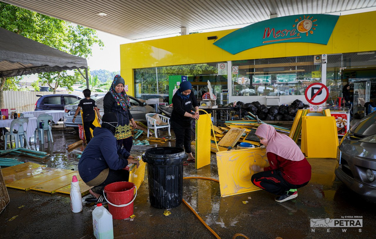 Pekerja Stesen Minyak Petronas di Kampung Sri Nanding, Hulu Langat membersihkan stesen minyak berkenaan yang sebelum ini ditenggelami air. - Gambar Syeda Imran