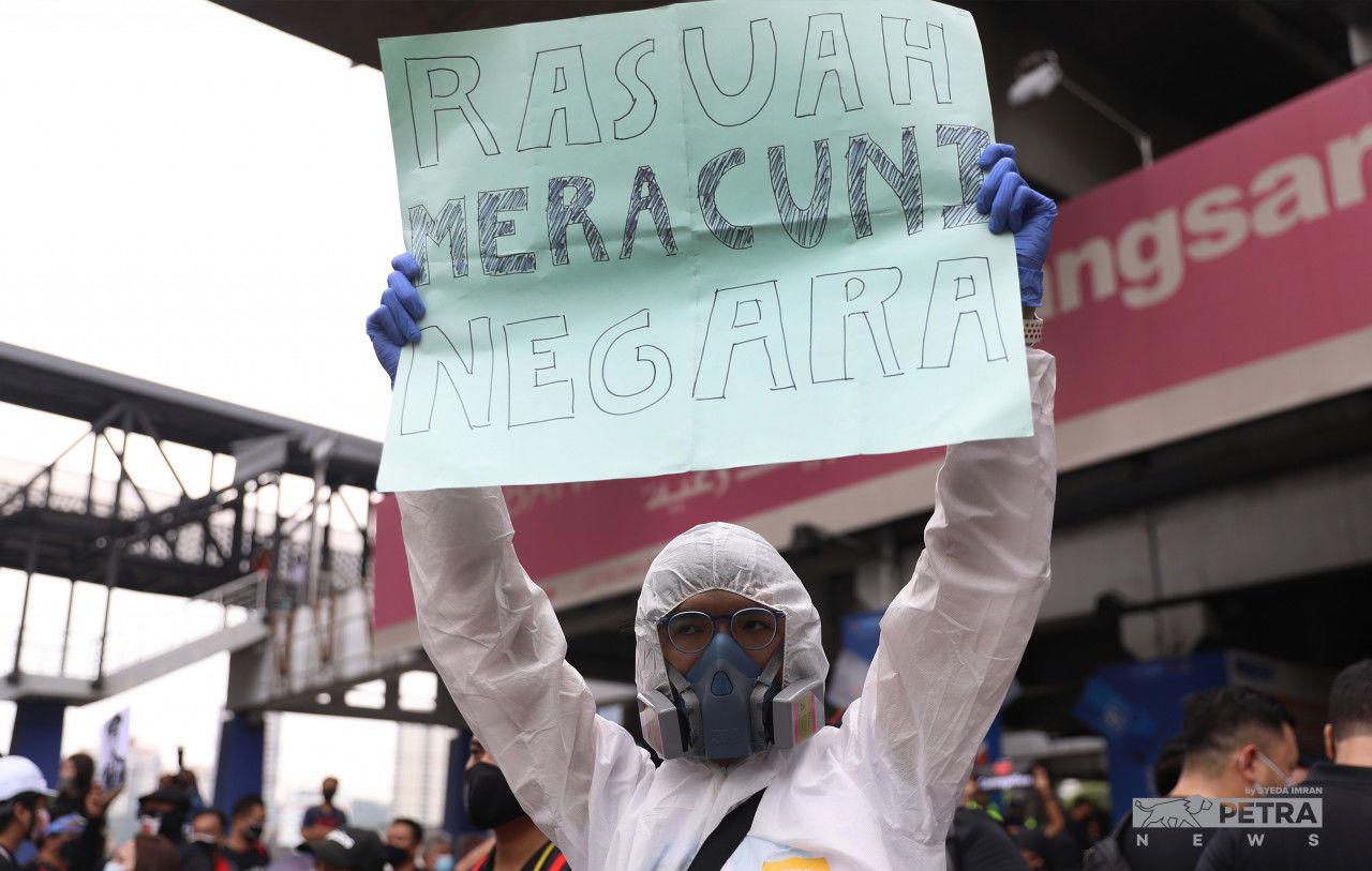 Salah seorang peserta mengangkat sepanduk mengenai rasuah.