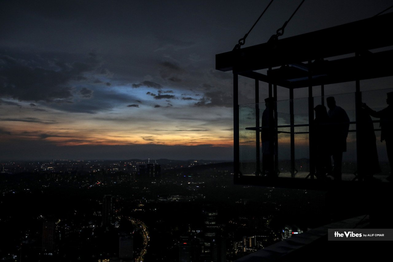 Pengunjung Menara Kuala Lumpur yang kuat semangat cuba berdiri di pelantar tinjau sementara menanti proses cerapan anak bulan Ramadan selesai. - Gambar oleh Alif Omar 