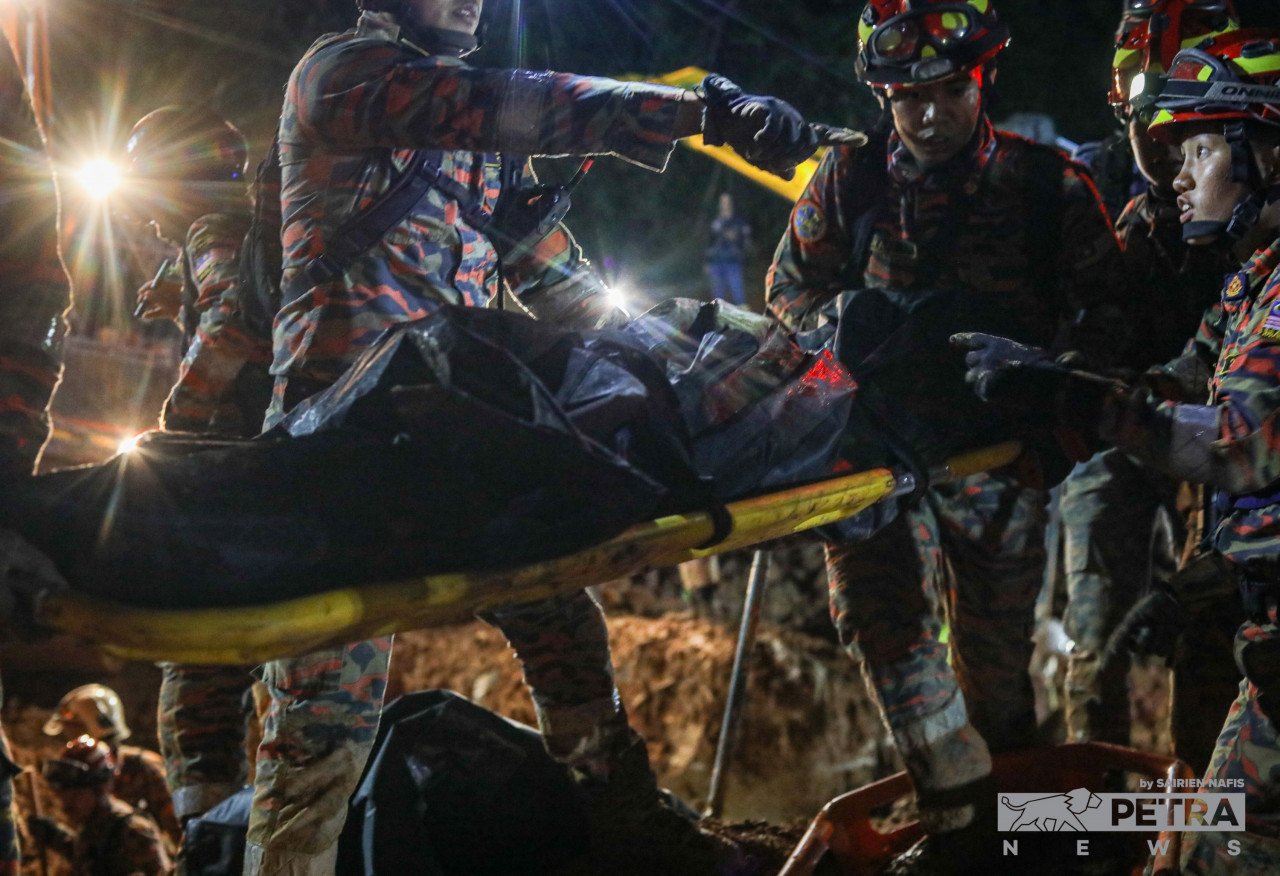 Pasukan SAR mengeluarkan mayat yang tertimbus dalam kejadian tanah runtuh di tapak perkhemahan Father's Organic Farm, Gohtong Jaya. - Gambar oleh Sairien Nafis
