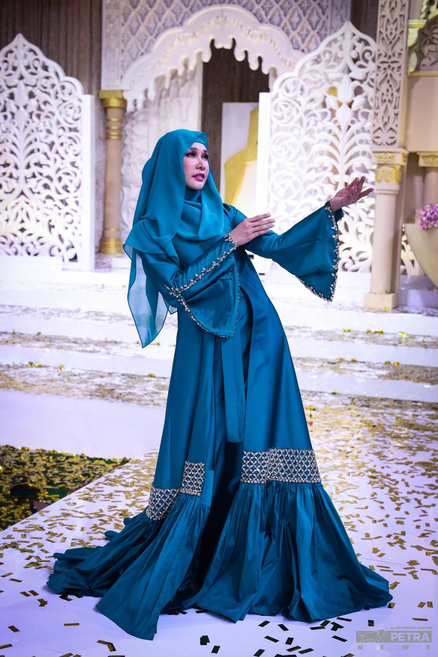 Nasha Aziz melangkah anggun ke pentas dengan memperagakan gaun jubah berona hijau zamrud sebagai pelengkap pertunjukan fesyen itu