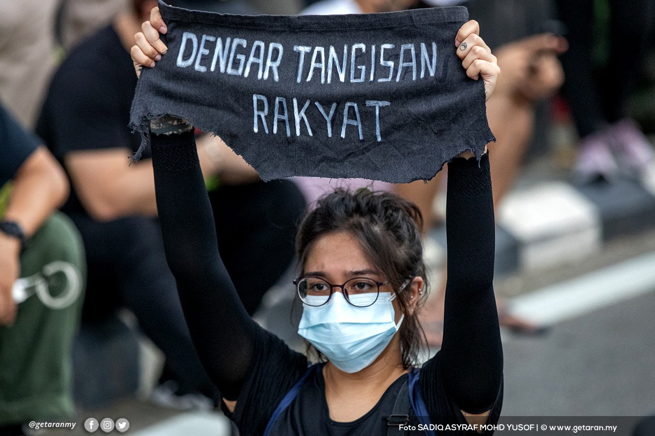 Seorang peserta wanita mengangkat kain rentang menggesa kerajaan mendengar keluhan dan tangisan rakyat. - Gambar Sadiq Asyraf