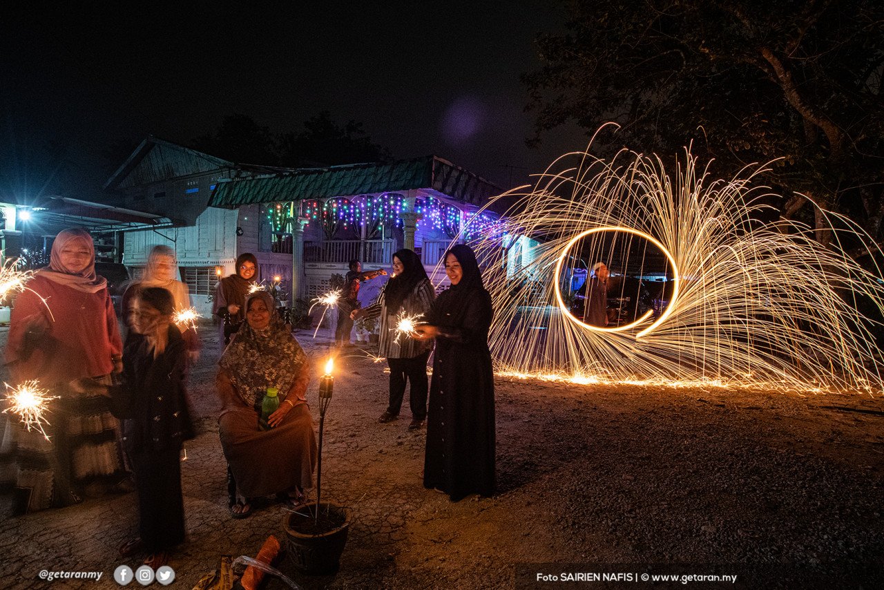 Suasana meriah di Banting apabila sekeluarga bermain bunga api dan memasang lampu minyak tanah, menandakan penghujung Ramadan dan bermulanya 1 Syawal.