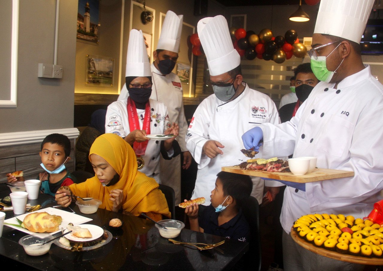 Pengarah Urusan The Pjoi's Cafe, Datuk Dr Shahrul Aman Zulkifli (dua, kanan) menyantuni golongan asnaf pada Program Chef Table bersama Asnaf.