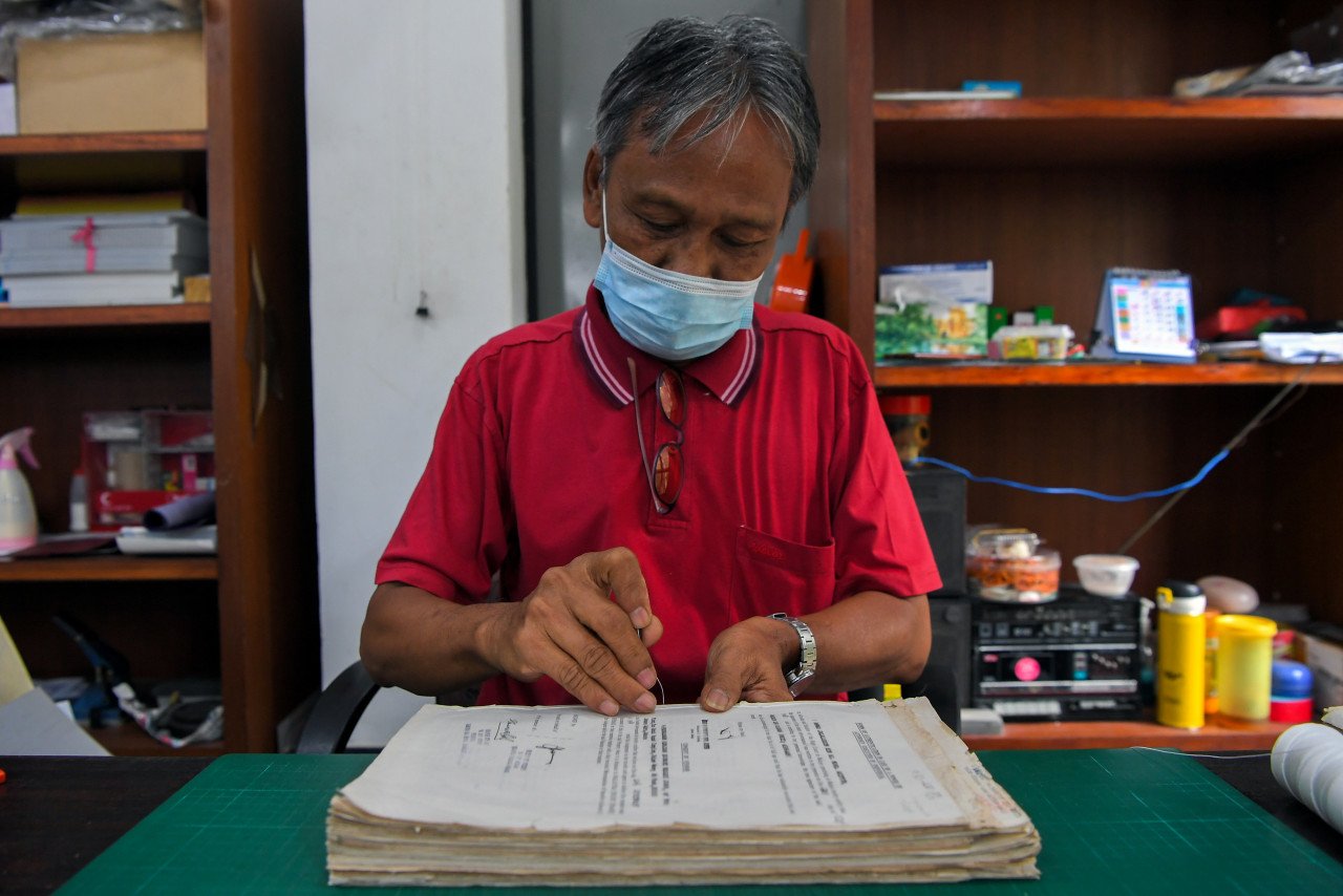 Pekerja Pertubuhan Pemulihan Kawasan Negeri Johor (JARO), Rahmat Arsat, Orang Kurang Upaya (OKU) anggota badan menjahit buku sebagai salah satu proses menjilid buku secara manual. 
