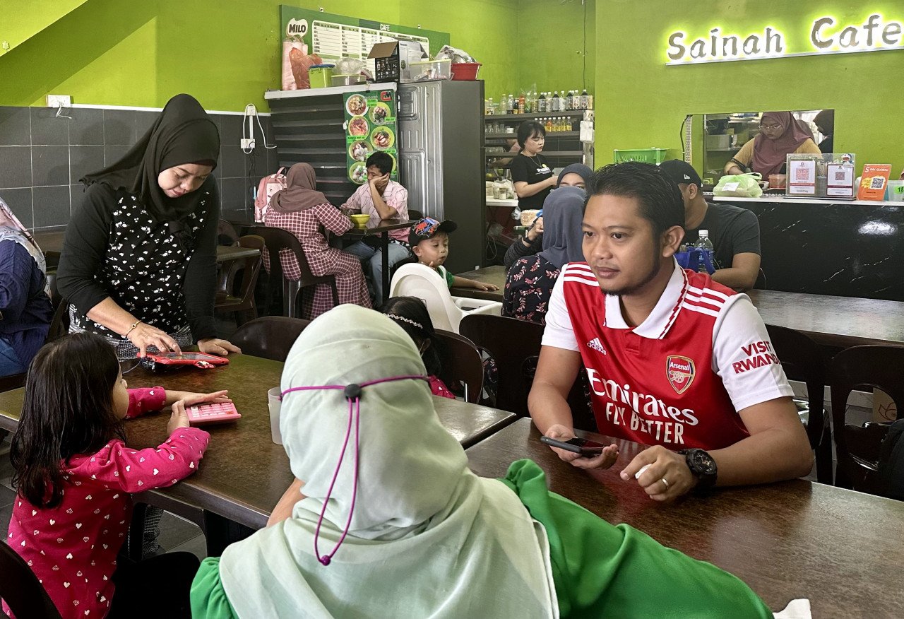 Pemilik Sainah Cafe, Sainah Mahdi, 41 (berdiri) melayan pelanggan yang berkunjung ke restorannya, di sini. gambar BERNAMA
