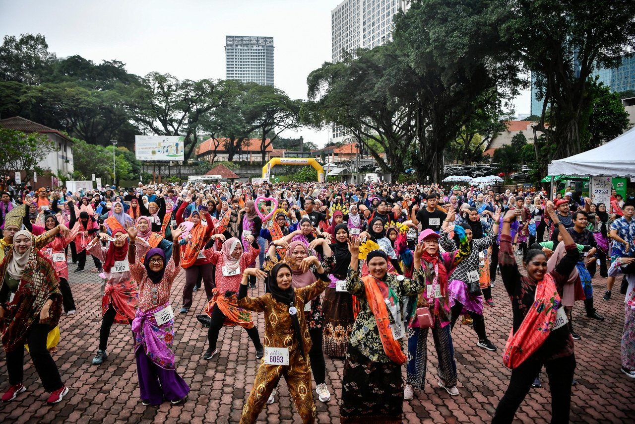 Peserta memanaskan badan sebelum program 'Batik Fun Walk 2023’ . gambar BERNAMA