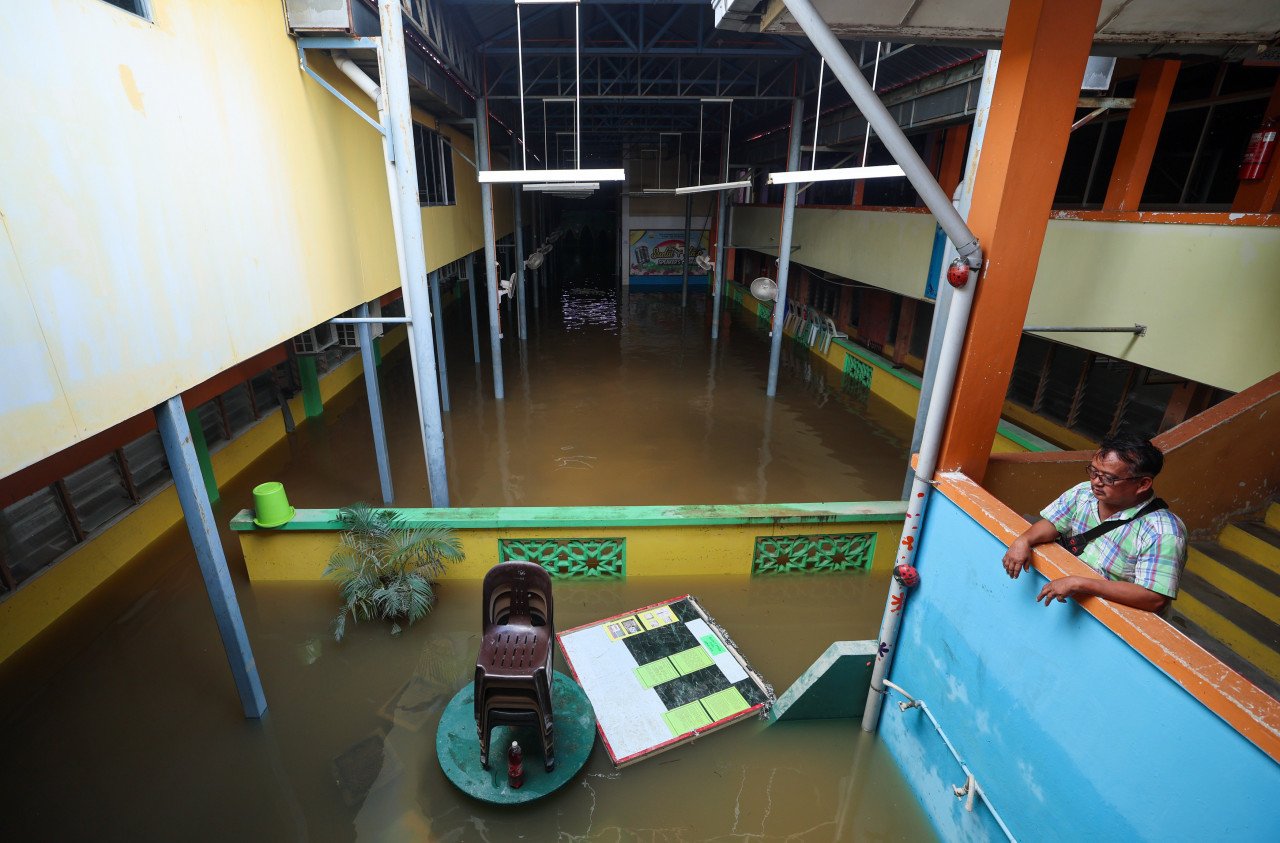 Pengawal Keselamatan Muhammad Navi, 57, memantau keadaan sekitar sekolah yang ditenggelami air disebabkan banjir yang berlaku sejak 26 Disember lalu di Sekolah Menengah Ugama (Arab) Al-Falah di Kampung Siram hari ini. – gambar BERNAMA