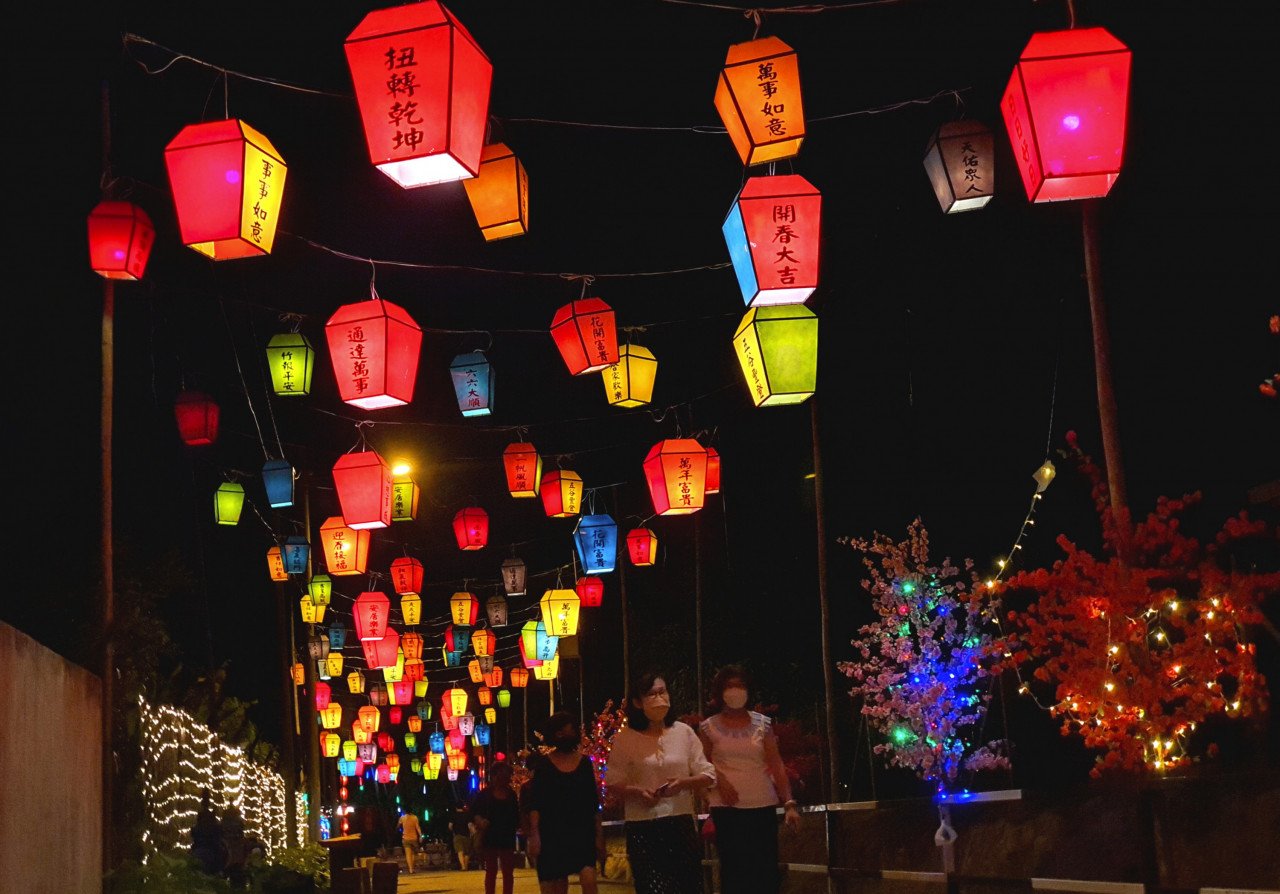 Pengunjung melalui Jalan Lampu Langit di Kampung Baru Machap Umboo yang dihiasai pelbagai lampu dan tanglung berwarna-warni.