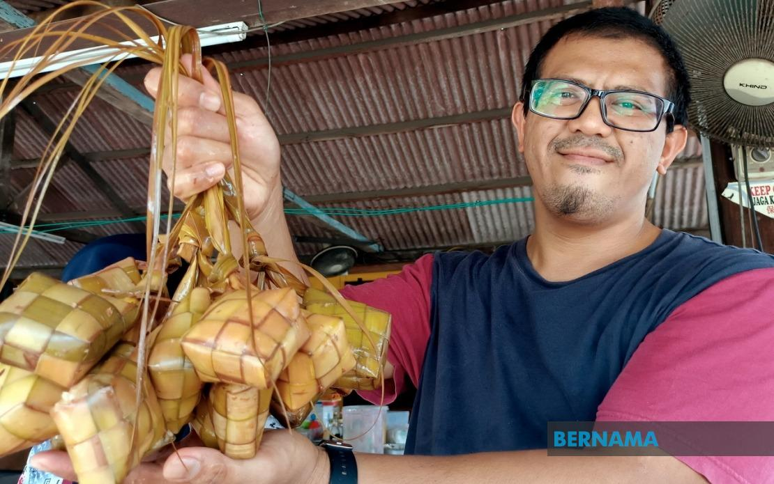 Mohamad Zaim Othman menunjukkan ketupat yang dijual di gerainya. - gambar BERNAMA