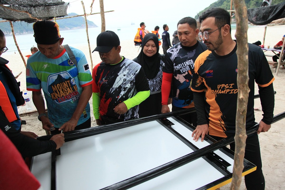 Sukarelawan UPSI memasang papan tanda untuk kegunaan Pantai Teluk Dalam, Pulau Redang