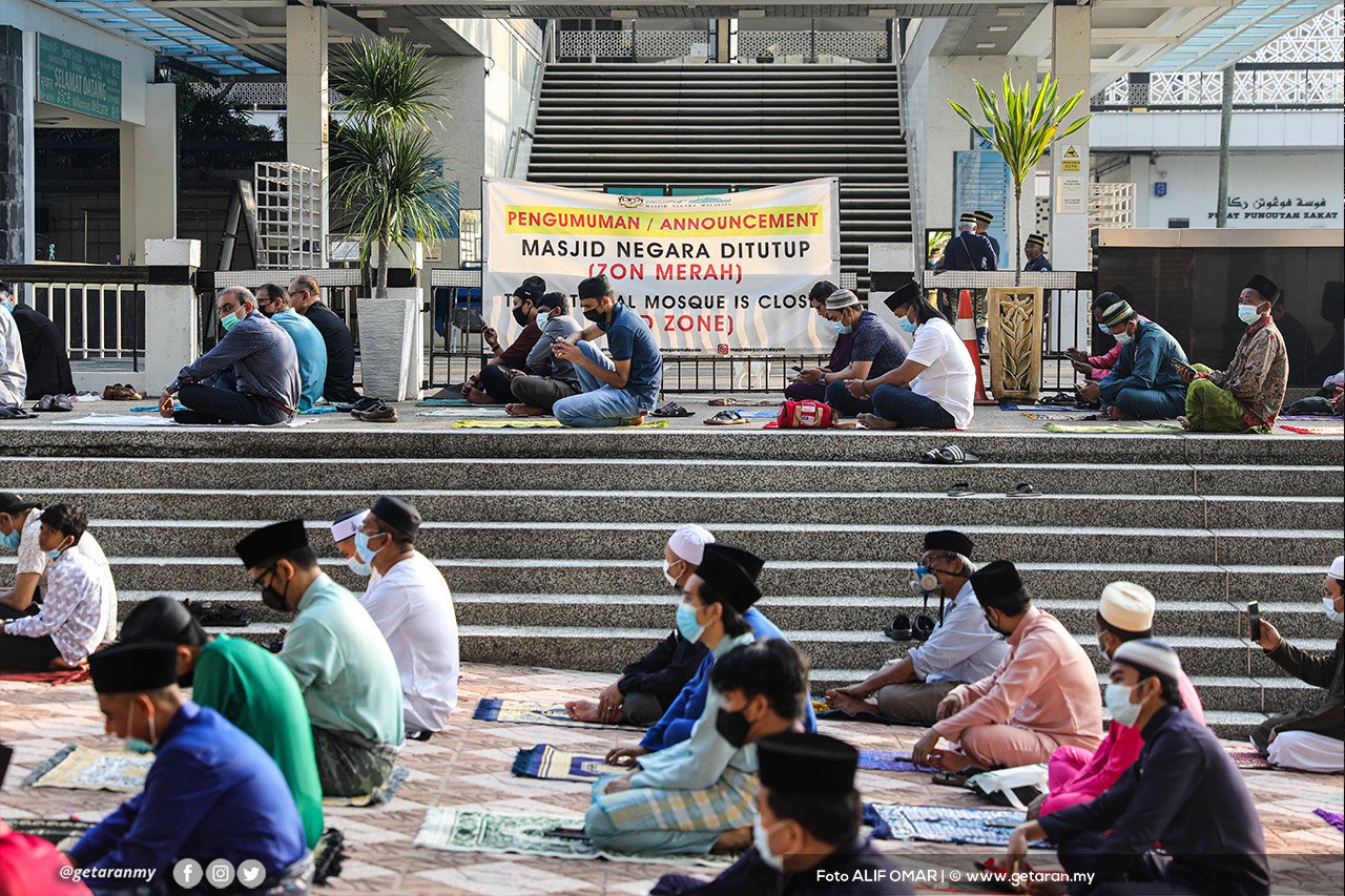 Orang ramai menunaikan solat sunat Aidilfitri di luar perkarangan Masjid Negara.