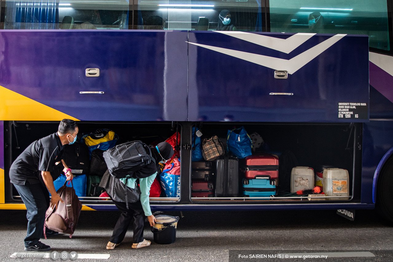 Pelajar ini memasukkan beg ke dalam bas untuk pulang ke kampung menerusi OPS Pulang Aidilfitri.