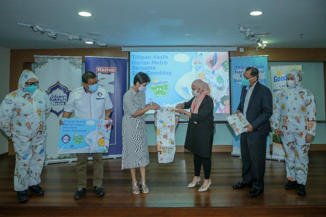 Pek Kuan (tiga dari kiri) menyerahkan set PPE yang dicetak lukisan tiga pemenang peraduan Goodday’s Happee PPEs kepada Ariesza di Hospital KPJ Damansara, baru-baru ini.
