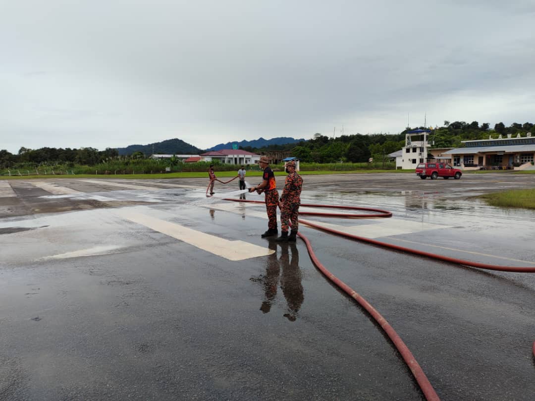 Anggota Bomba sedang menjalankan kerja-kerja pembersihan di kawasan landasan yang terjejas akibat banjir.