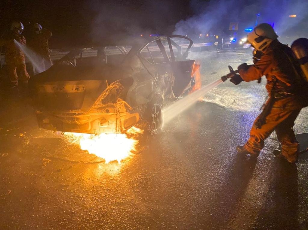 Seorang anggota Bomba bertungkus lumus memadamkan kebakaran kereta Nissan Almeira.