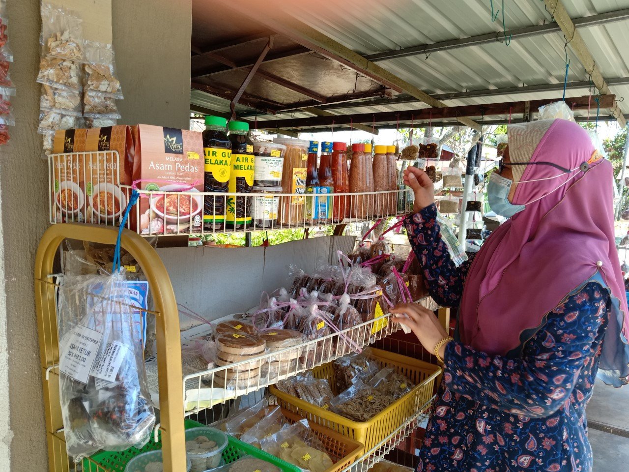 Junaidah Maarof memeriksa barang jualannya di Kampung Pinang, Melaka