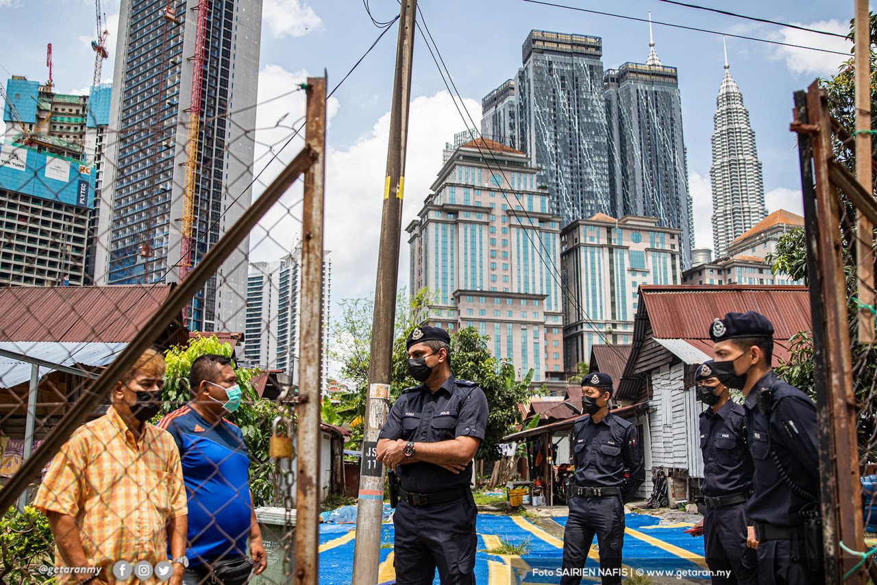 Inspektor T Yogakanesh (tiga dari kiri) dari Bahagian Siasatan Narkotik bersama anggota IPD Dang Wangi membuat pemantauan dan pemeriksaan rumah ke rumah ketika Aidilfitri bagi memastikan tiada aktiviti kunjung-mengunjung di sekitar Kampung Baru, Kuala Lumpur.