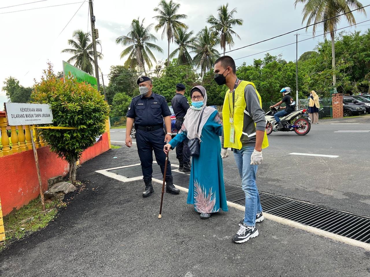 Seorang pengundi warga emas mendapat bantuan untuk ke pusat pengundian di SK Durian Daun, Lendu. - Gambar Aiman Sadiq