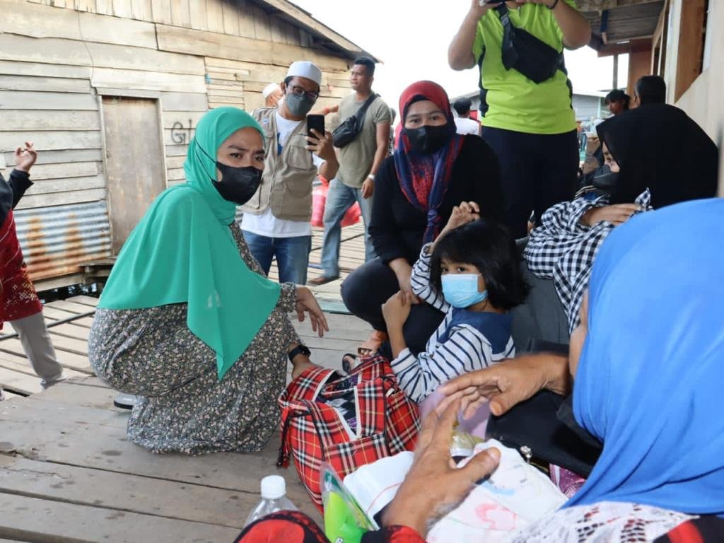 Rina (kiri) melawat mangsa kebakaran Kampung Kurnia Jaya Batu 4, Jalan Apas.