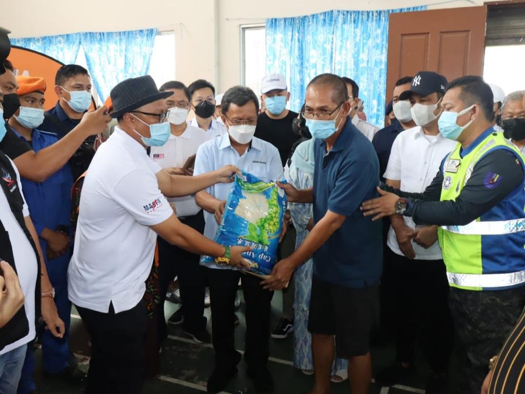 Mohd Shafie (tengah) menyampaikan sumbangan kepada mangsa kebakaran di Kampung Kurnia Jaya.
