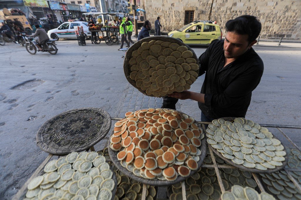 Seorang peniaga menghasilkan manisan 'Qatayef' di bandar al-Bab di Syria. - Gambar AFP