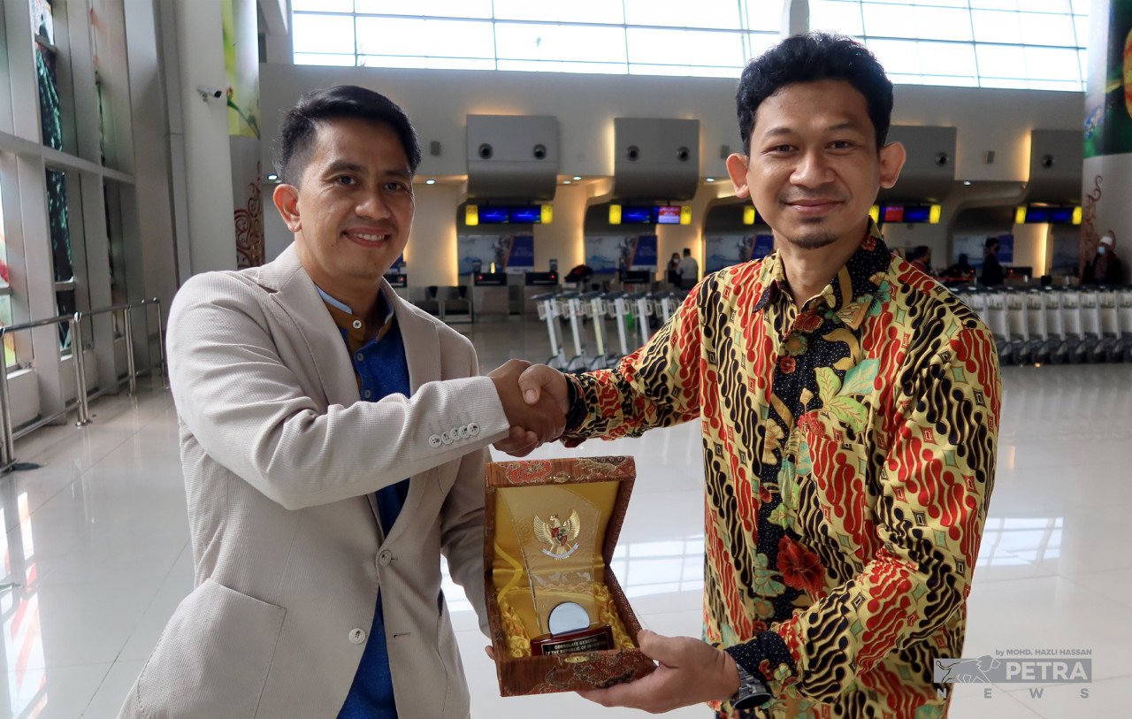 Aryadi Ramadhan (kiri) menyerahkan cenderamata kepada Chandra Nurhidayat semasa program pengenalan pelancongan ke Jawa Timur baru-baru ini. - Gambar oleh Mohd Hazli Hassan