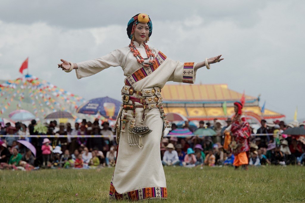 Seorang wanita Tibet mengenakan perhiasan dan pakaian tradisional untuk satu persembahan, pada tahun 2016. - Gambar AFP