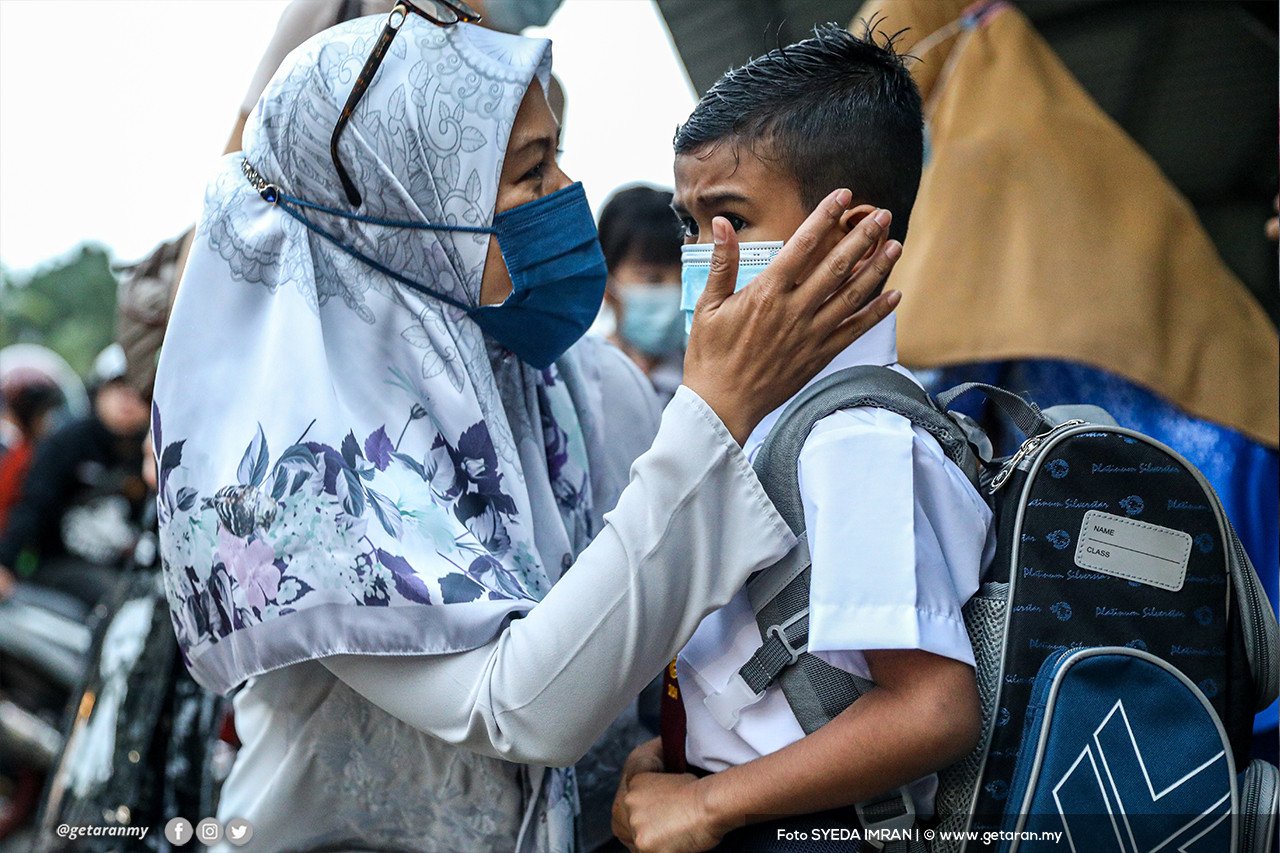Seorang ibu menenangkan anaknya yang gementar sebelum memulakan sesi persekolahan. - Gambar Syeda Imran