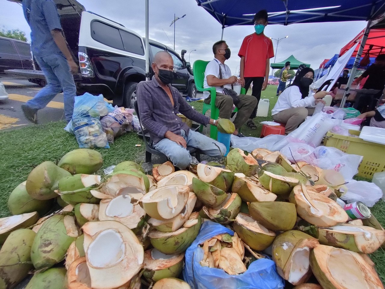Penjual air kelapa Abraham Salleh menjual 60 paket air kelapa di bazar Ramadan pekan Sandakan dalam masa dua jam sahaja. - Gambar oleh Rebecca Chong