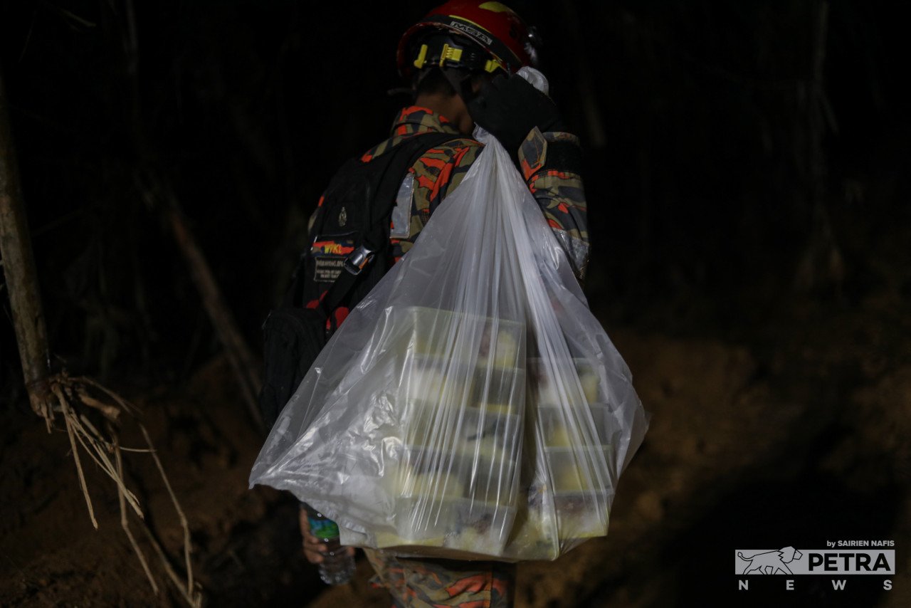 Seorang anggota bomba membawa makanan untuk rakan yang bertugas. - Gambar oleh Sairien Nafis