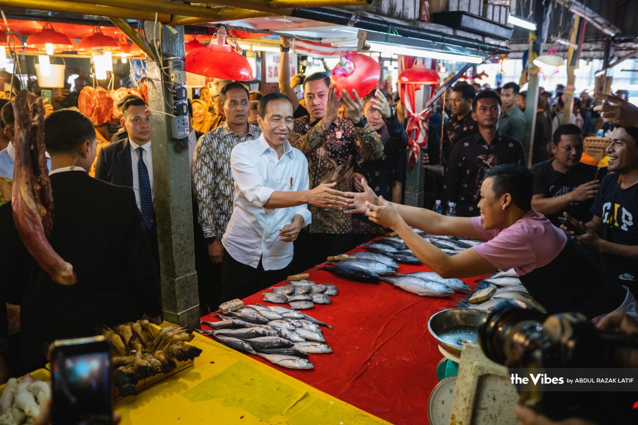 Jokowi bersalam dengan salah seorang penjual ikan di Pasar Chow Kit, hari ini. - Gambar oleh Abdul Razak Latif