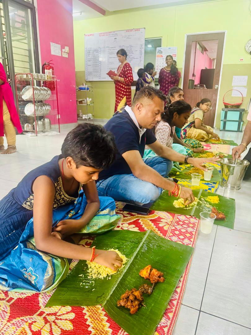 Sivakumar Nadarajah (dua, kiri) tidak kekok bersila di lantai bersama anak-anak yatim bagi menikmati hidangan disajikan