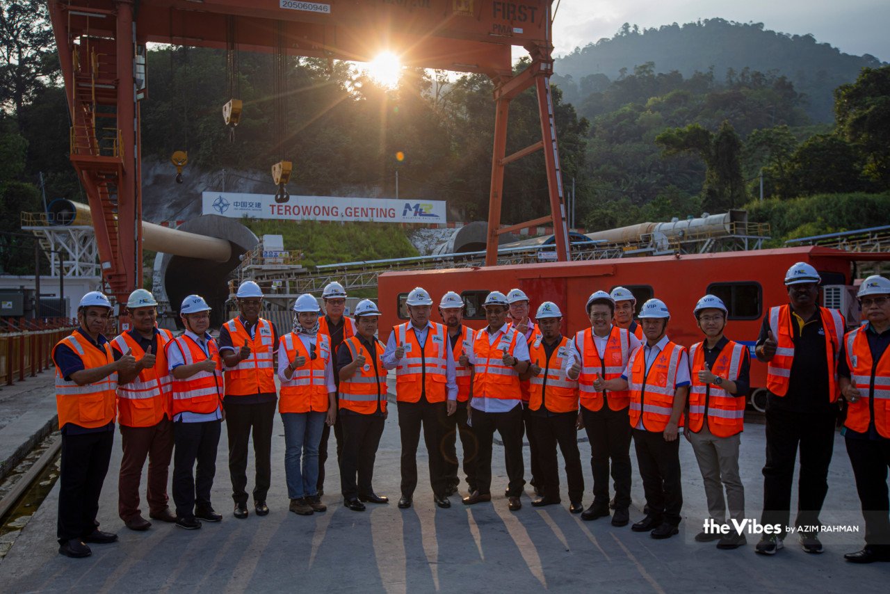 Anthony Loke bersama pekerja Malaysia Rail Link Sdn Bhd (MRL) bergambar membelakangi tapak penembusan Terowong Genting projek Laluan Rel Pantai Timur.