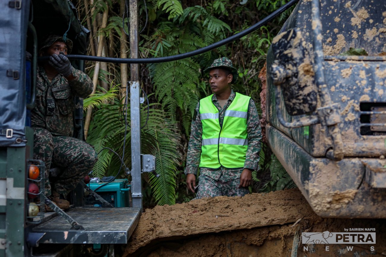 Seorang anggota tentera mengisi minyak dalam jengkaut yang digunakan dalam misi mencari dan menyelamat mangsa tragedi tanah runtuh di Father's Organic Farm. - Gambar oleh Sairien Nafis