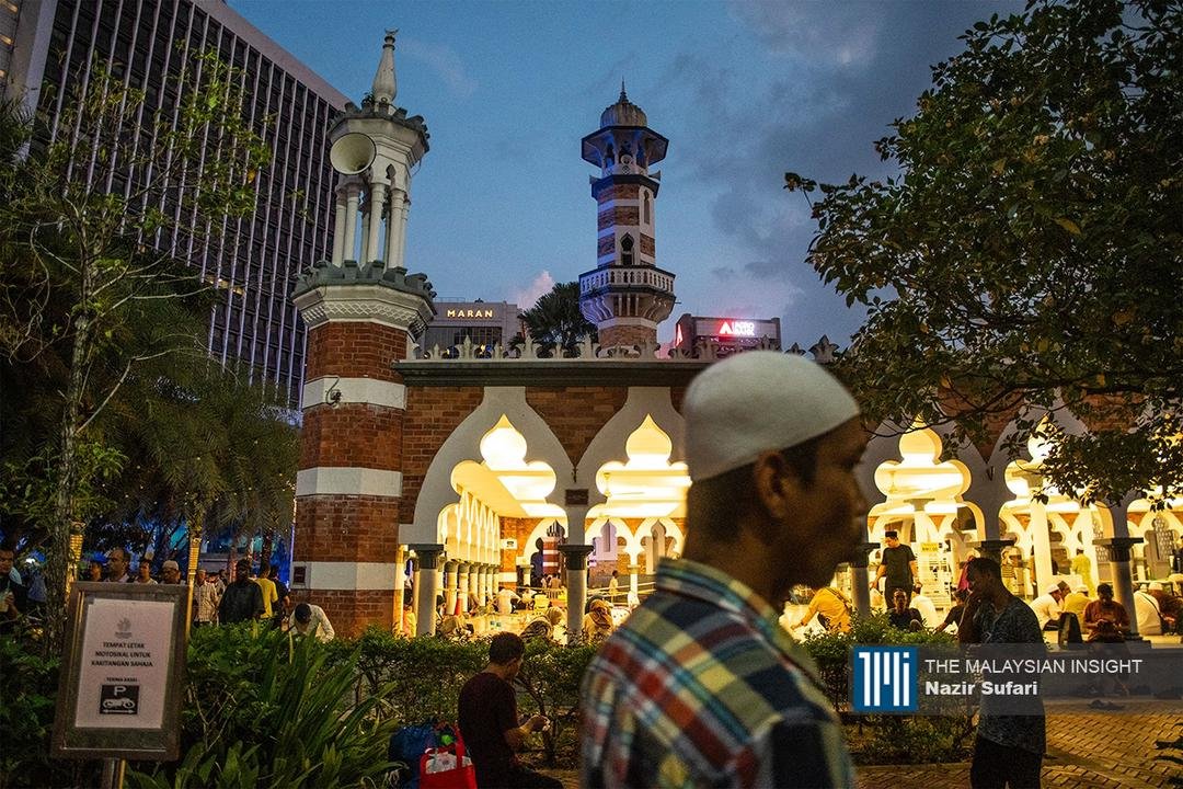 Seorang jemaah lelaki melintasi Masjid Jamek Kuala Lumpur untuk menunaikan solat Tarawih