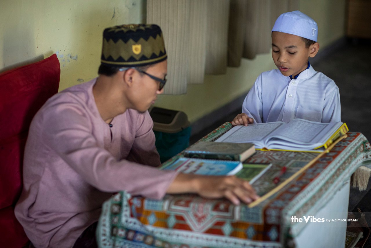 Pelajar tahfiz membaca al-Quran sambil diajar oleh Ustaz Muhammad Amar Abd Rahman (kiri) 