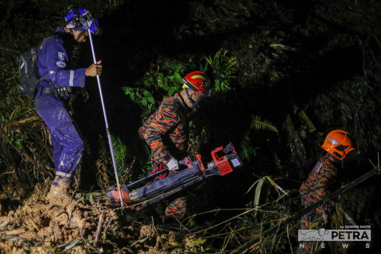 Anggota Bomba dan SMART membawa lampu ke tapak kejadian tanah runtuh untuk menyambung operasi mencari dan menyelamat. - Gambar oleh Sairien Nafis